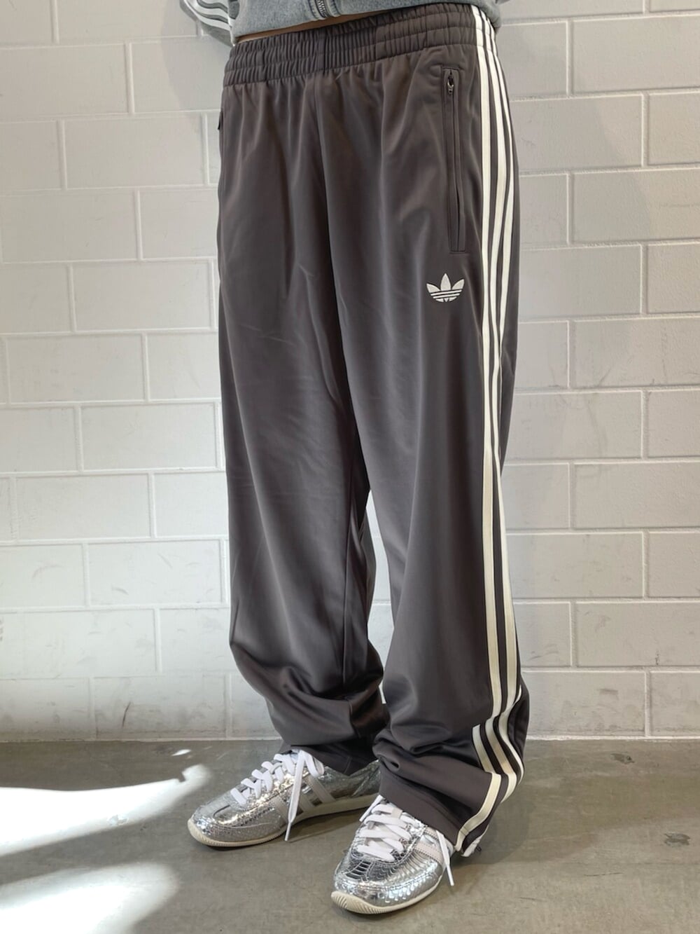 シルバー系のスニーカー、ブルー系のデニムジャケット、グレー系のその他パンツを着用したレディースの春コーディネートの5枚目の写真