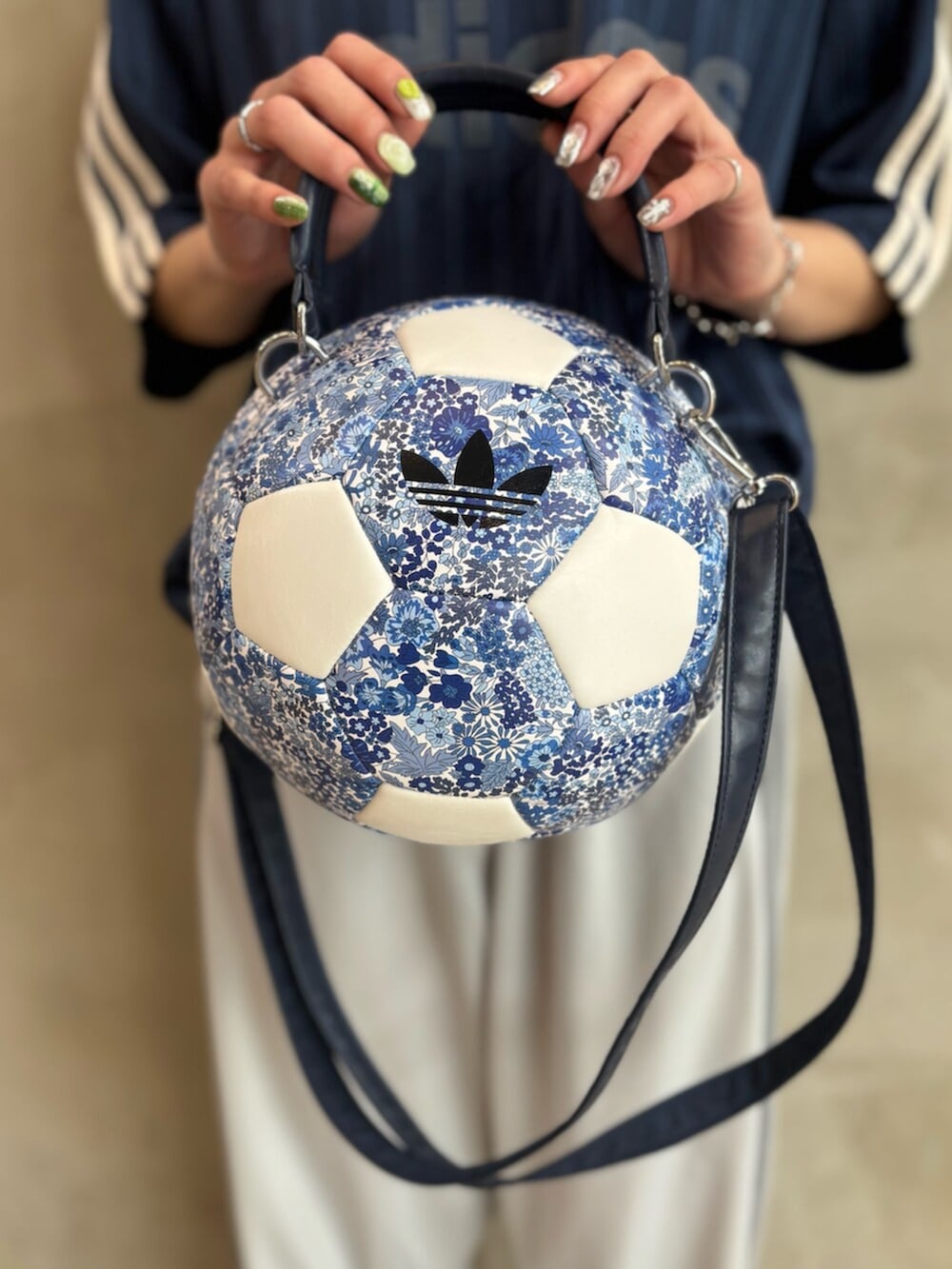 ブルー系のスニーカー、グレー系のパンツ、ホワイト系のバッグを着用したレディースの春コーディネートの5枚目の写真