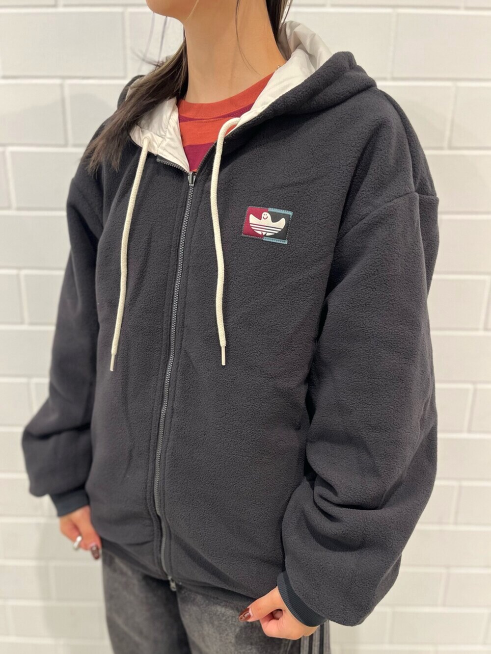 グレー系のシューズ、ブラック系のデニムパンツ、ベージュ系のブルゾンを着用したレディースの秋コーディネートの4枚目の写真