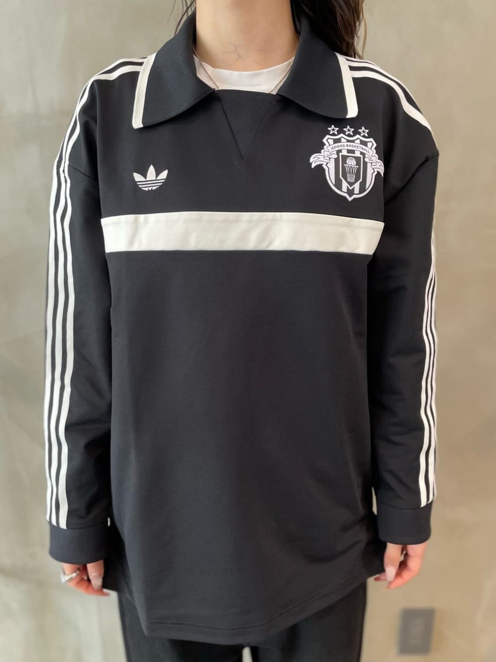 レッド系のスニーカー、ブラック系のトップス、ブラック系のハットを着用したレディースの春コーディネートの5枚目の写真