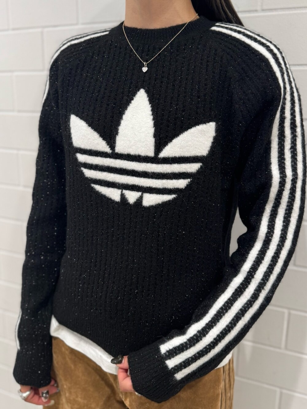 シルバー系のショルダーバッグ、ブラック系のスウェット、ブラウン系のその他パンツを着用したレディースの秋コーディネートの3枚目の写真