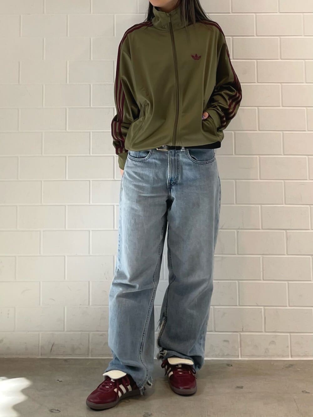 レッド系のスニーカー、グリーン系のジャージを着用したレディースの春コーディネートの2枚目の写真