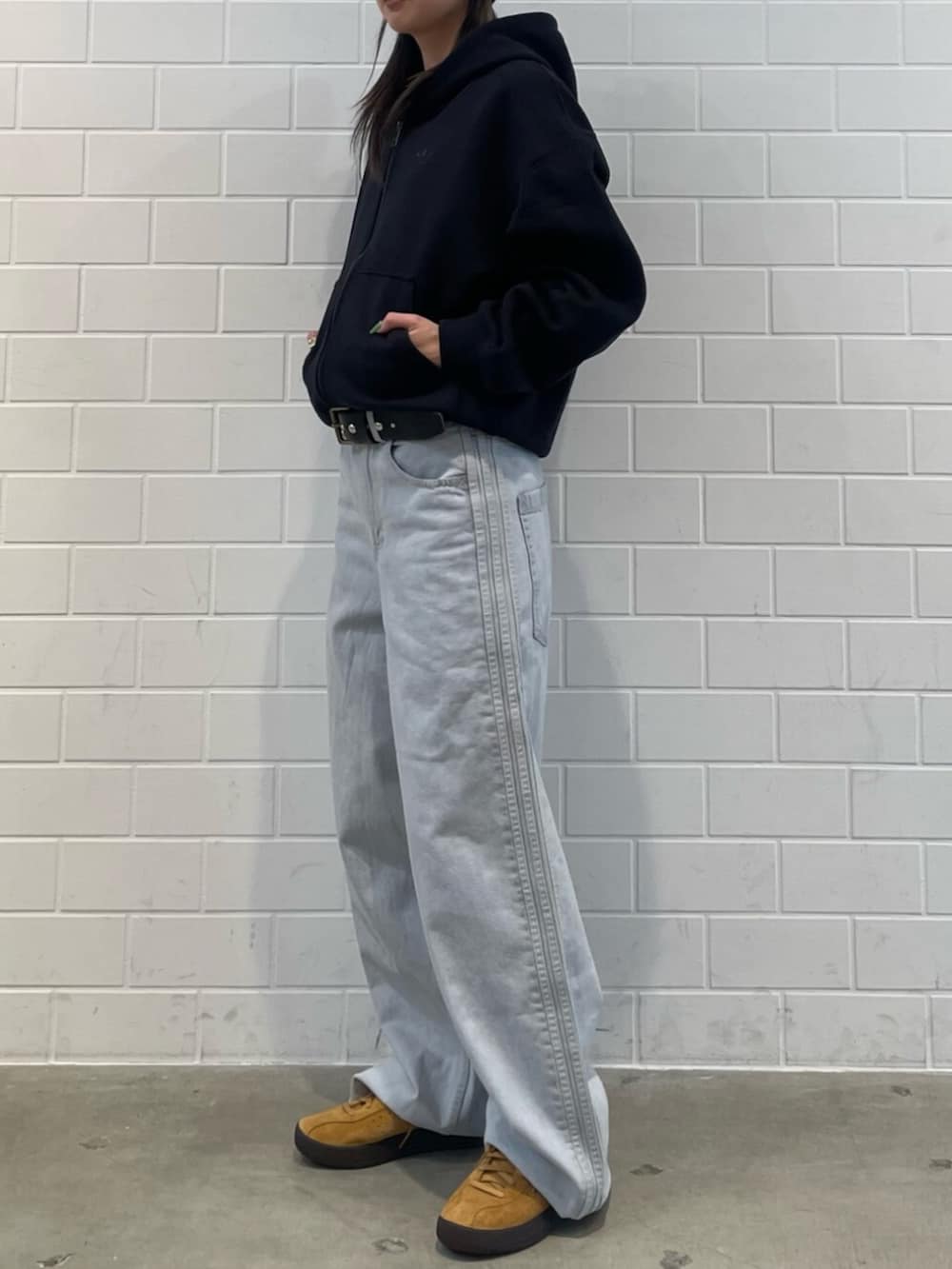 ブルー系のその他パンツ、ブラック系のパーカー、イエロー系のシューズを着用したレディースの冬コーディネートの2枚目の写真