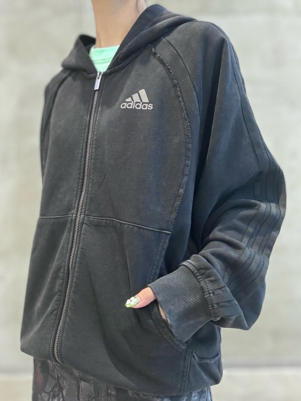 ブラック系のパーカー、ブラック系のその他パンツ、ブラウン系のスニーカーを着用したレディースの夏コーディネートの3枚目の写真