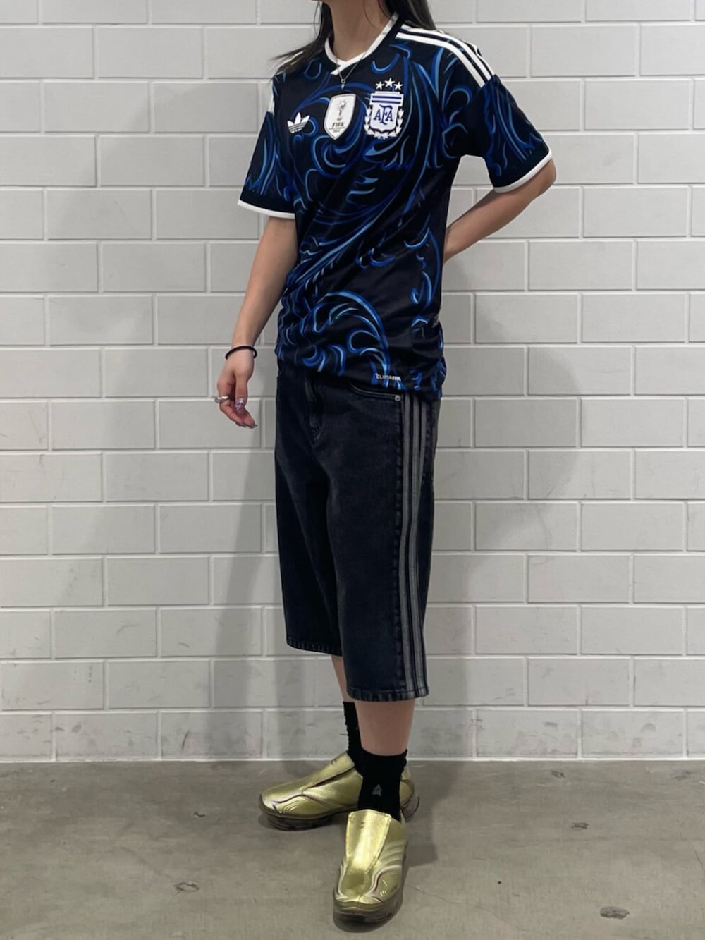 ゴールド系のシューズ、ブラック系のTシャツ/カットソー、ブラック系のデニムパンツを着用したレディースの春コーディネートの2枚目の写真