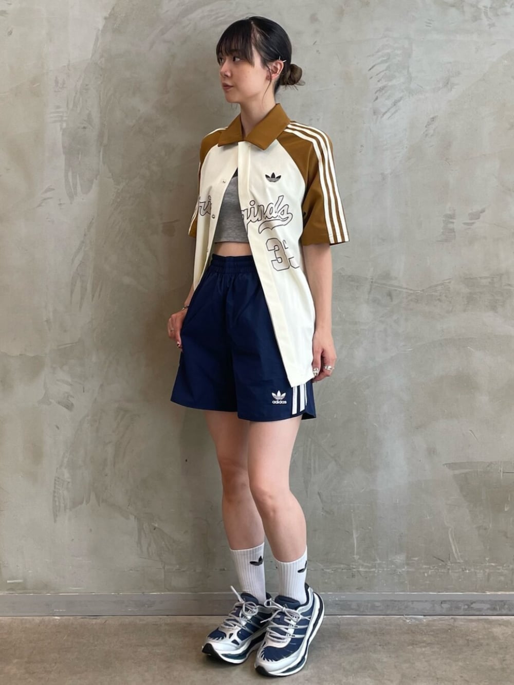 ベージュ系のトップス、ブルー系のスウェットパンツ、ブルー系のスニーカーを着用したレディースの夏コーディネートの3枚目の写真