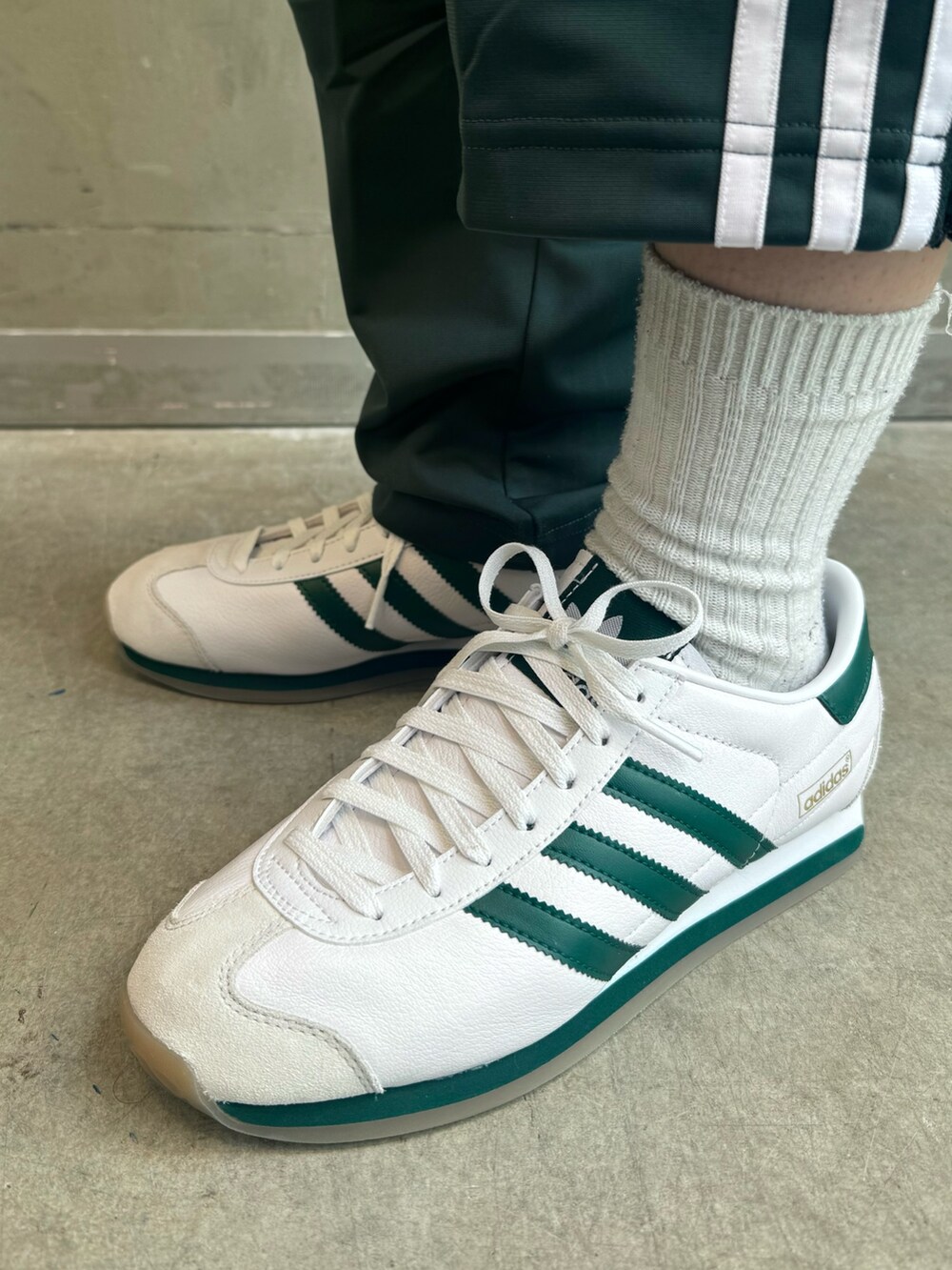 ブラック系のダウンジャケット/コート、ホワイト系のポロシャツ、グリーン系のスウェットパンツを着用したレディースの秋コーディネートの9枚目の写真