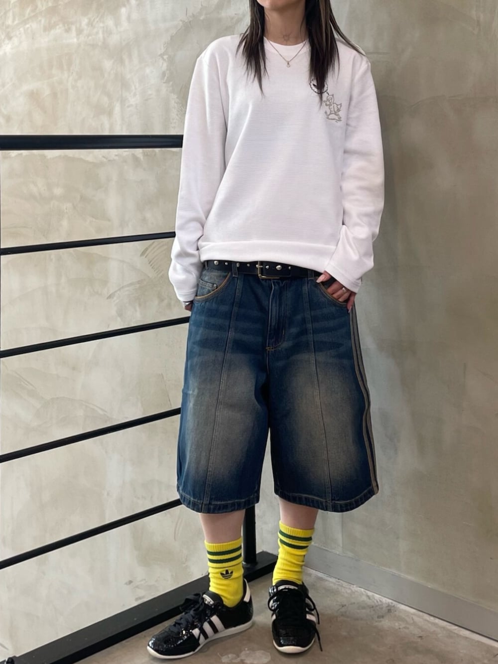 ホワイト系のTシャツ/カットソー、ブラック系のスニーカー、イエロー系のレッグウェアを着用したレディースの冬コーディネートの2枚目の写真