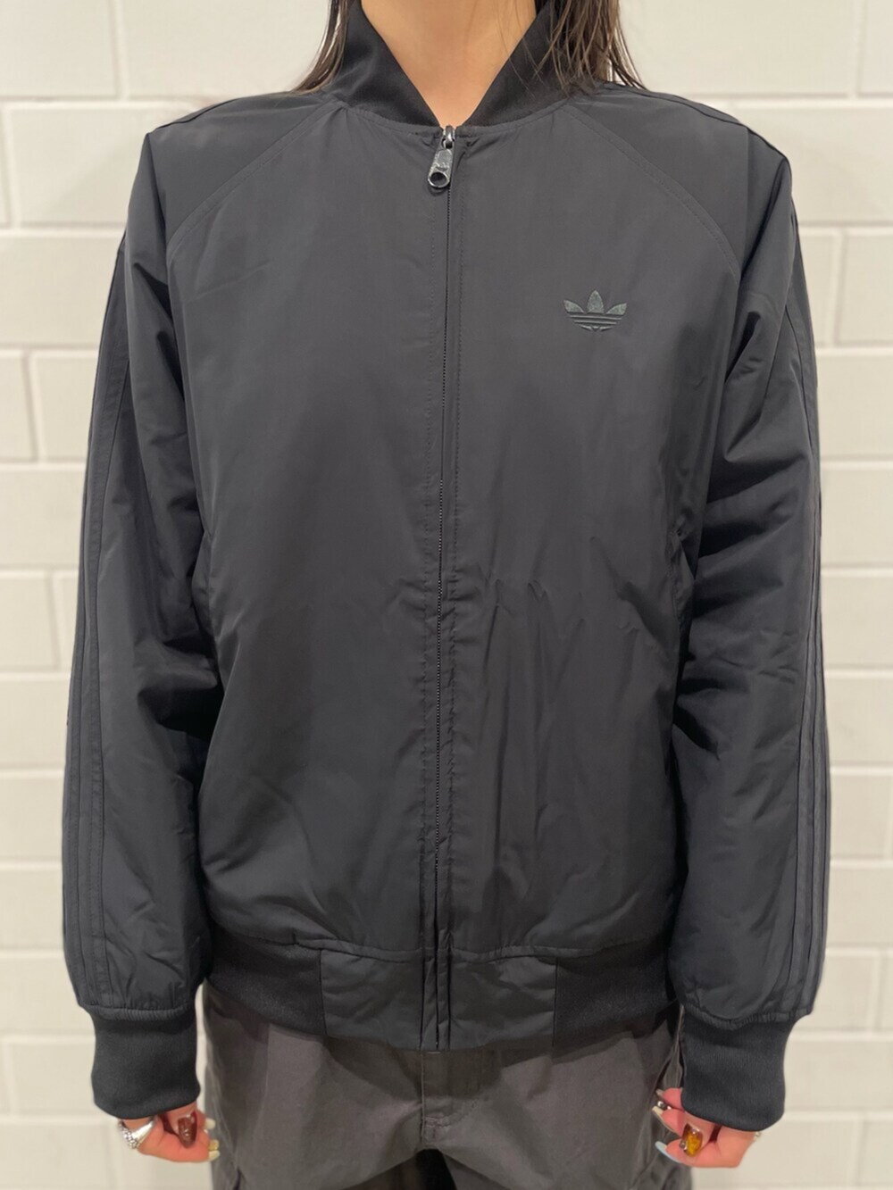 ブラック系のTシャツ/カットソー、ブラック系のブルゾン、グレー系のその他パンツを着用したレディースの冬コーディネートの4枚目の写真