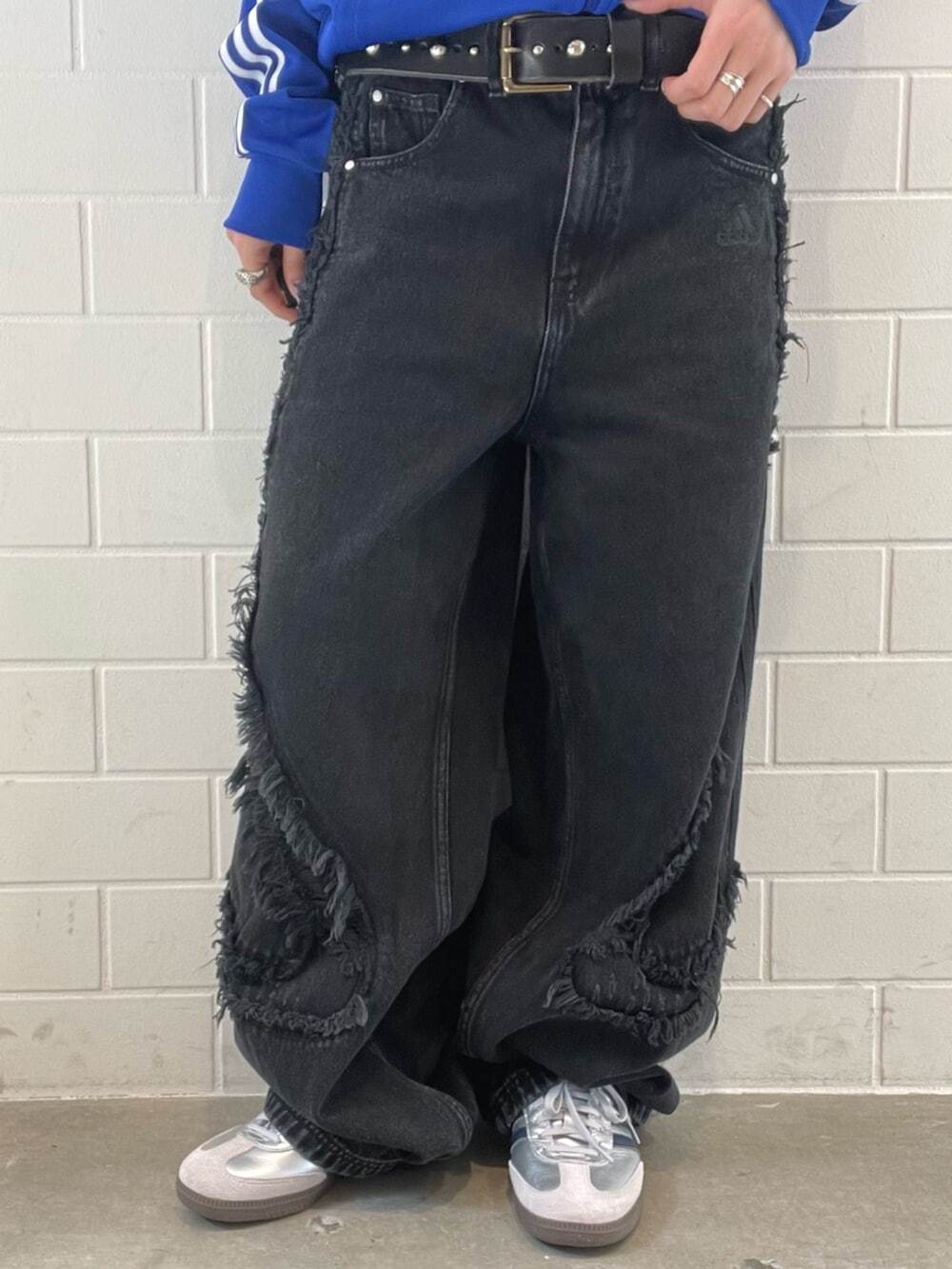 シルバー系のスニーカー、ブラック系のデニムパンツ、ブルー系のジャージを着用したレディースの春コーディネートの5枚目の写真