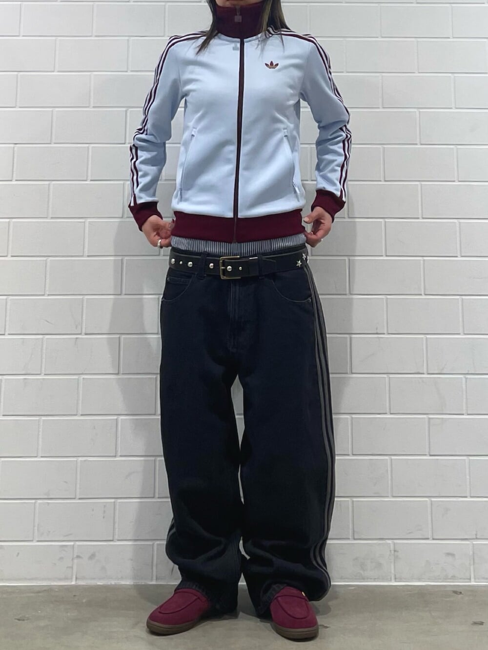 レッド系のスニーカー、ブルー系のトップス、ブラック系のデニムパンツを着用したレディースの春コーディネートの2枚目の写真