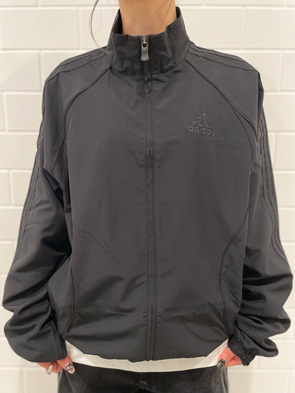 ブラック系のデニムパンツ、ブラック系のスニーカー、ブラック系のジャージを着用したレディースの冬コーディネートの4枚目の写真