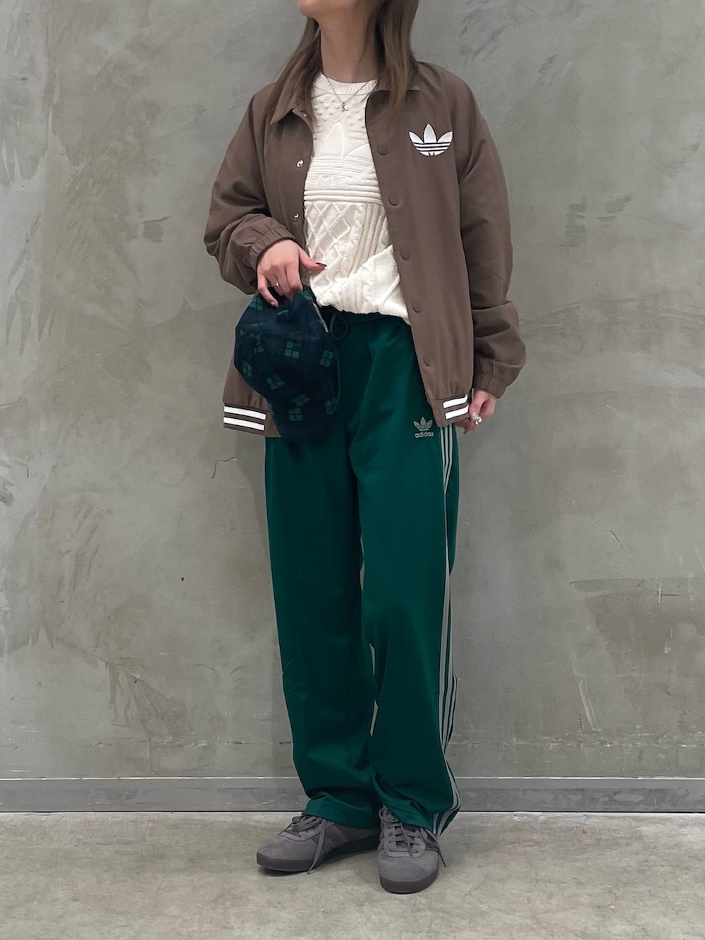 ブラウン系のジャケット/アウター、ホワイト系のニット/セーター、グレー系のスニーカーを着用したレディースの冬コーディネートの2枚目の写真