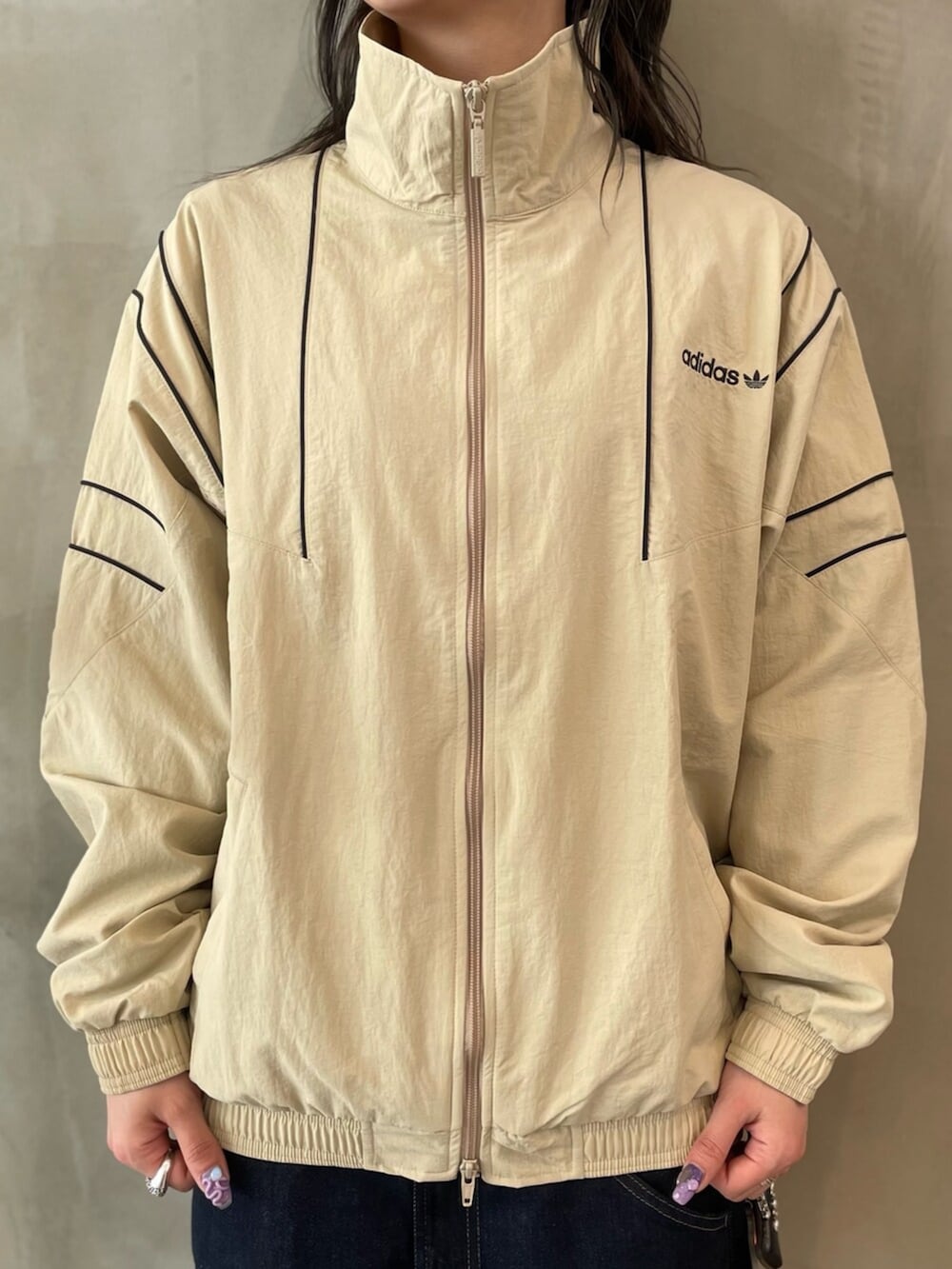 ベージュ系のジャージ、ホワイト系のスニーカーを着用したレディースの春コーディネートの3枚目の写真