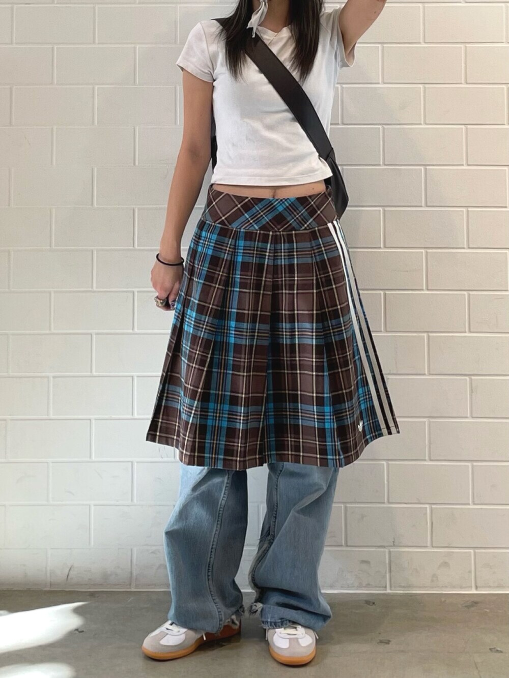 ブラウン系のスカート、ブラウン系のショルダーバッグ、ホワイト系のシューズを着用したレディースの春コーディネートの2枚目の写真