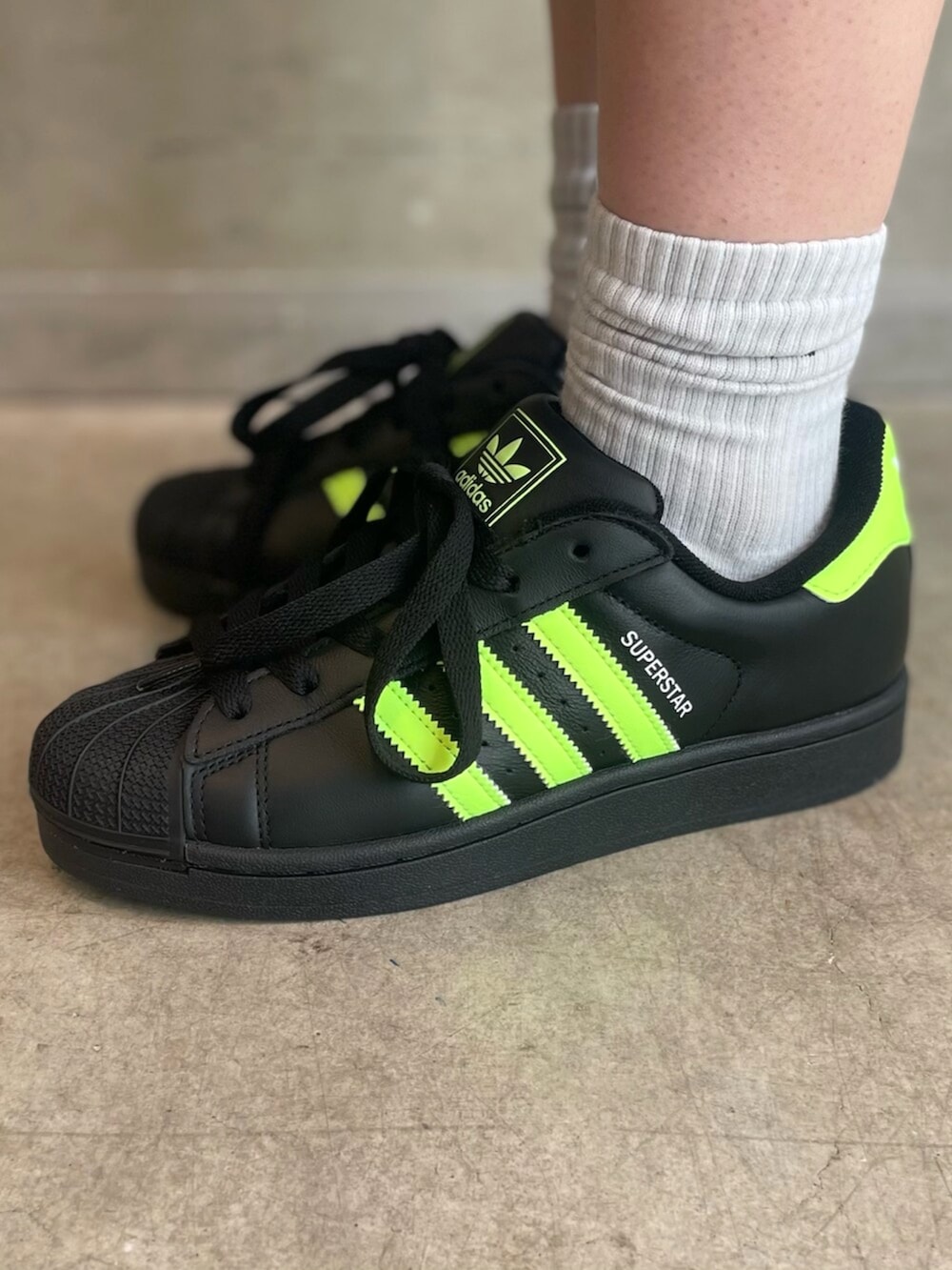 ブラック系のスニーカー、ブラック系のショルダーバッグ、シルバー系のスウェットパンツを着用したレディースの秋コーディネートの6枚目の写真