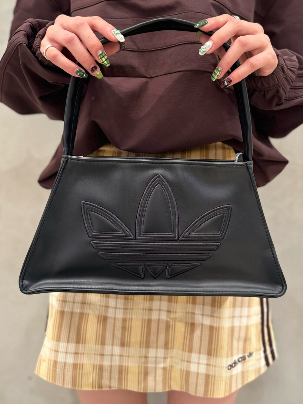 ブラウン系のTシャツ/カットソー、ベージュ系のスカート、ブラック系のショルダーバッグを着用したレディースの秋コーディネートの5枚目の写真