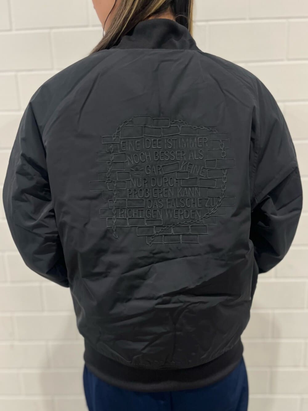 ブルー系のスウェットパンツ、ブラック系のブルゾン、ブラック系のスニーカーを着用したレディースの秋コーディネートの6枚目の写真