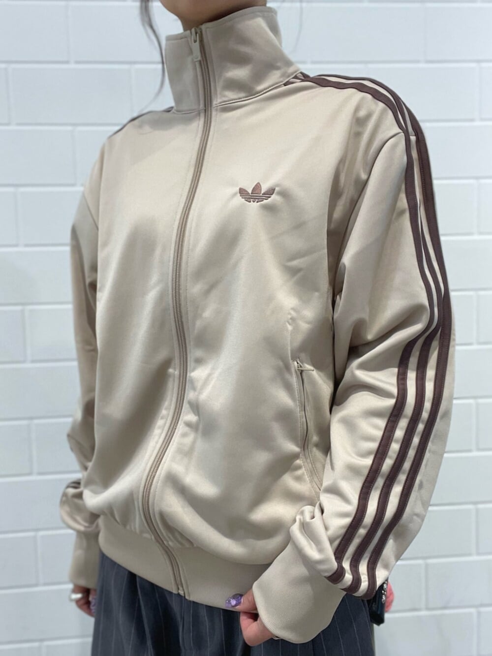 ブラック系のスニーカー、ベージュ系のトップス、ベージュ系のショルダーバッグを着用したレディースの春コーディネートの4枚目の写真