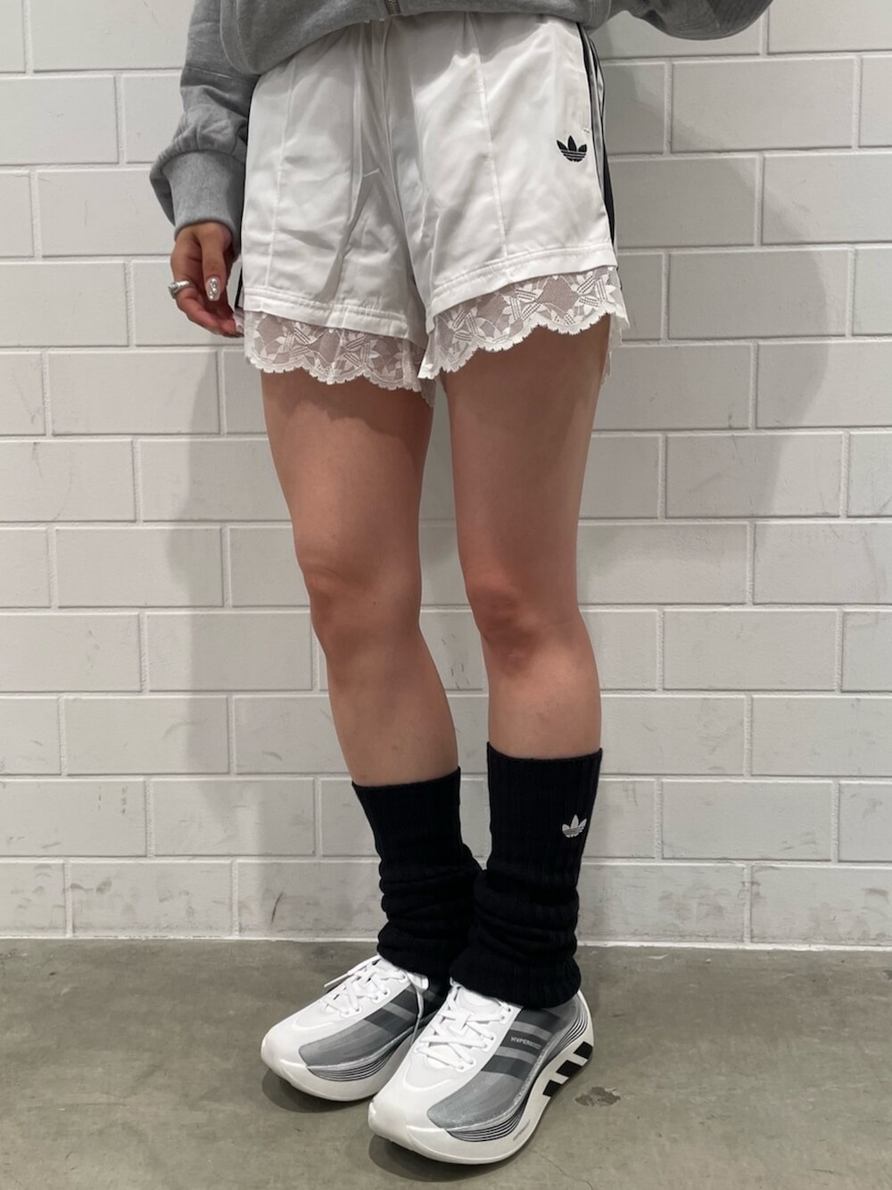 ホワイト系のその他パンツ、グレー系のパーカー、ブラック系のスニーカーを着用したレディースの秋コーディネートの5枚目の写真