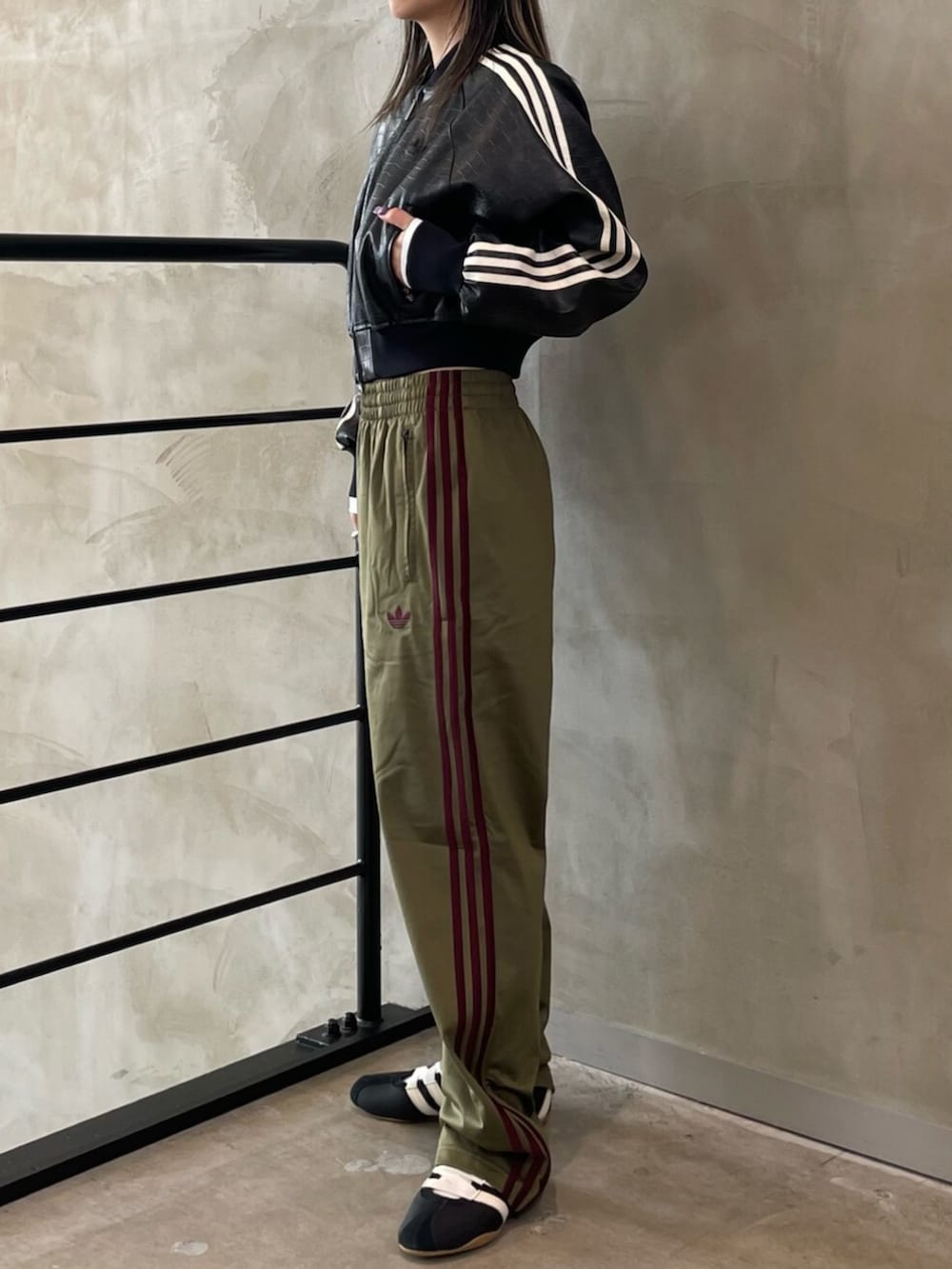 ブラック系のスニーカー、ブラック系のブルゾン、ホワイト系のトップスを着用したレディースの春コーディネートの2枚目の写真