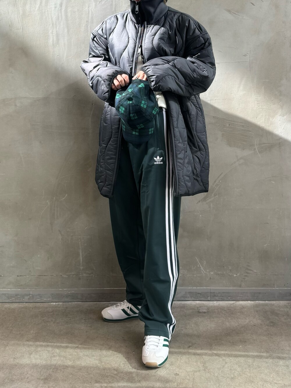 ブラック系のダウンジャケット/コート、ホワイト系のポロシャツ、グリーン系のスウェットパンツを着用したレディースの秋コーディネートの2枚目の写真