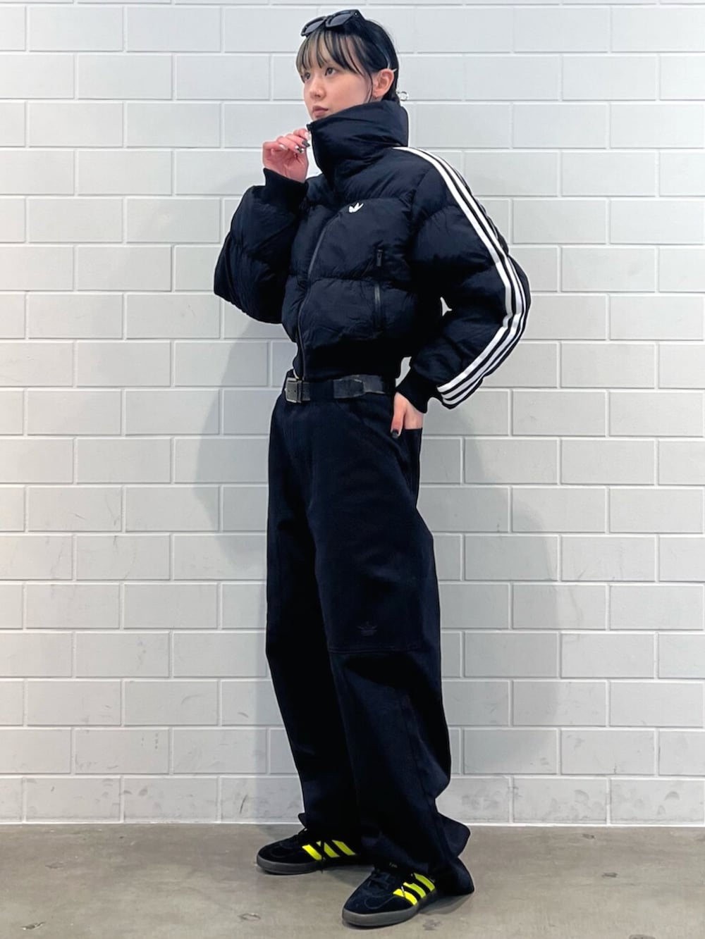 ホワイト系のTシャツ/カットソー、ブラック系のスニーカー、ブラック系のダウンジャケット/コートを着用したレディースの秋コーディネートの3枚目の写真