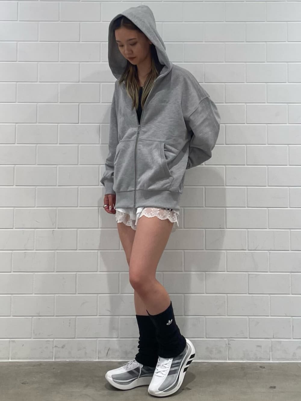 ホワイト系のその他パンツ、グレー系のパーカー、ブラック系のスニーカーを着用したレディースの秋コーディネートの3枚目の写真