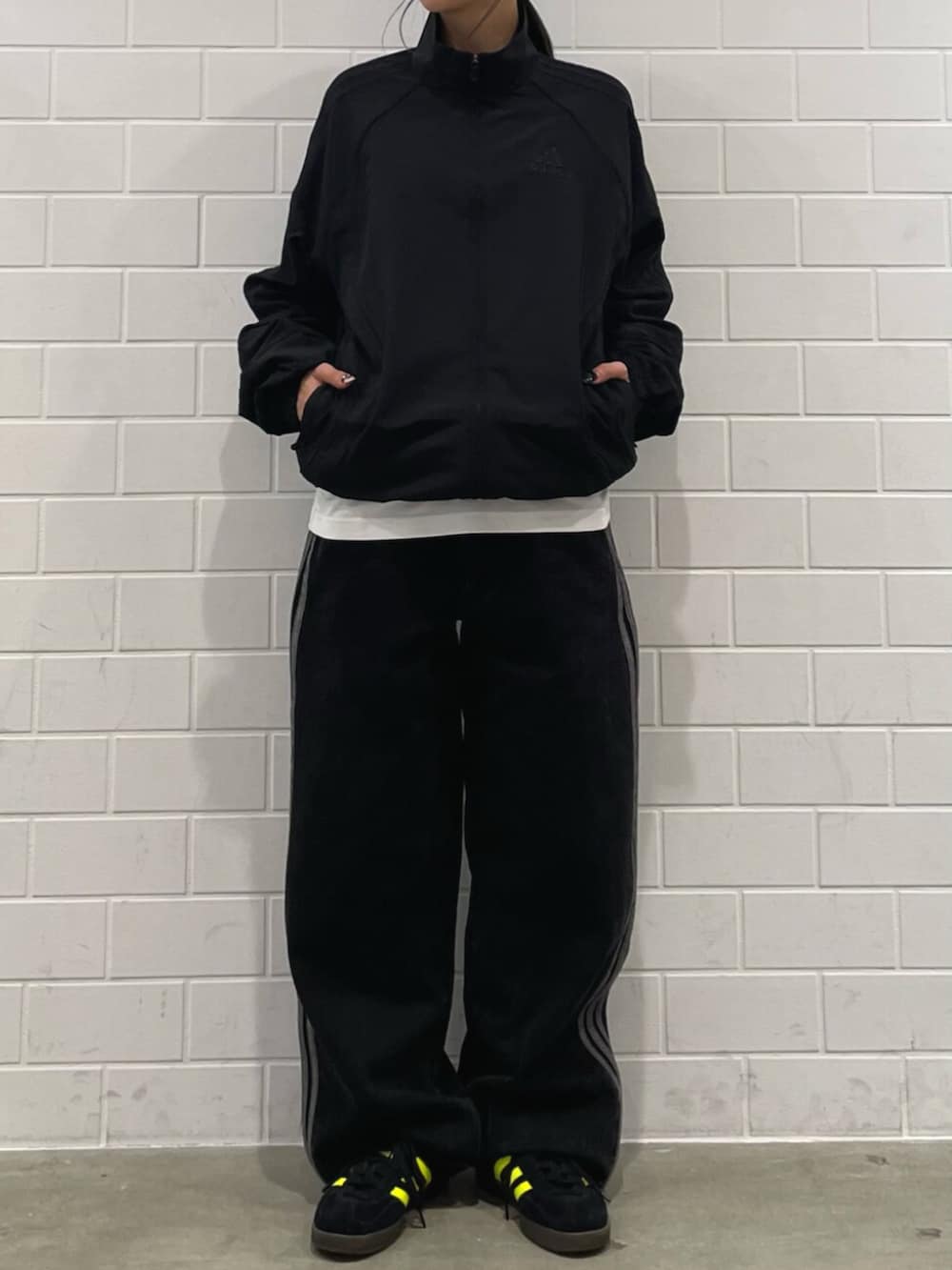 ブラック系のデニムパンツ、ブラック系のスニーカー、ブラック系のジャージを着用したレディースの冬コーディネートの2枚目の写真