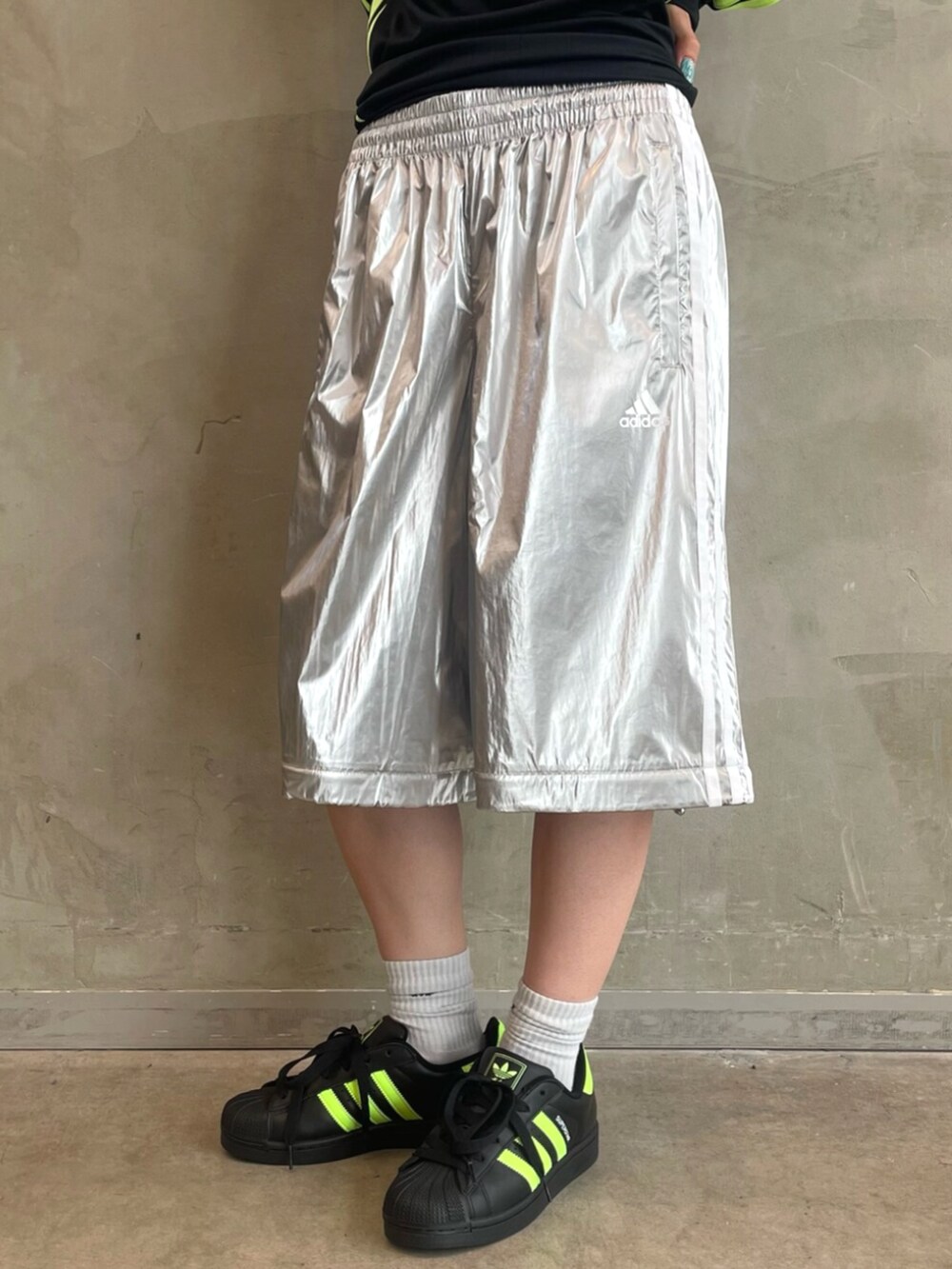 ブラック系のスニーカー、ブラック系のショルダーバッグ、シルバー系のスウェットパンツを着用したレディースの秋コーディネートの5枚目の写真