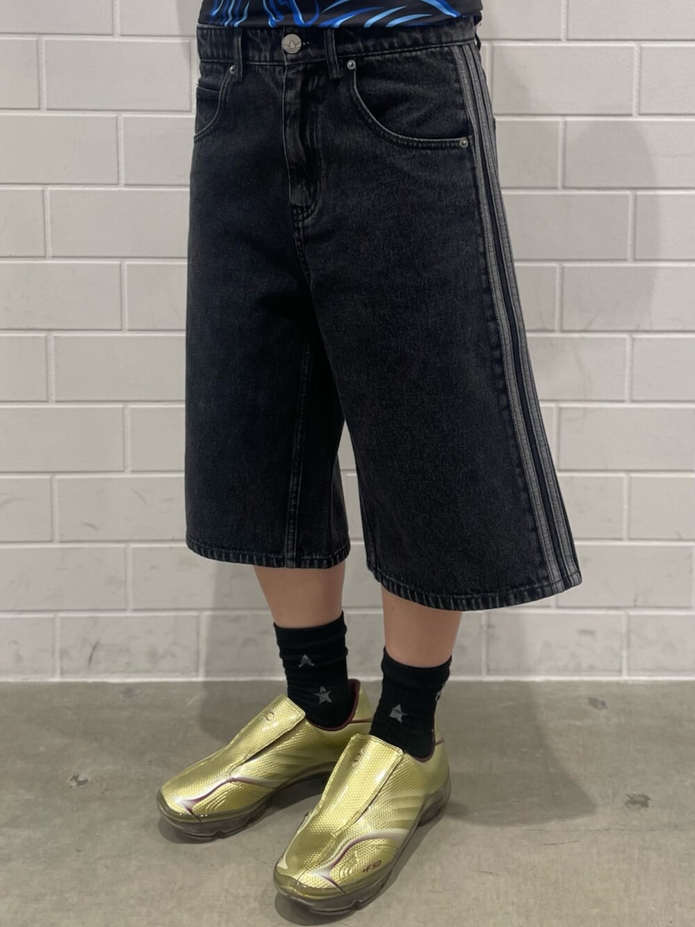 ゴールド系のシューズ、ブラック系のTシャツ/カットソー、ブラック系のデニムパンツを着用したレディースの春コーディネートの5枚目の写真