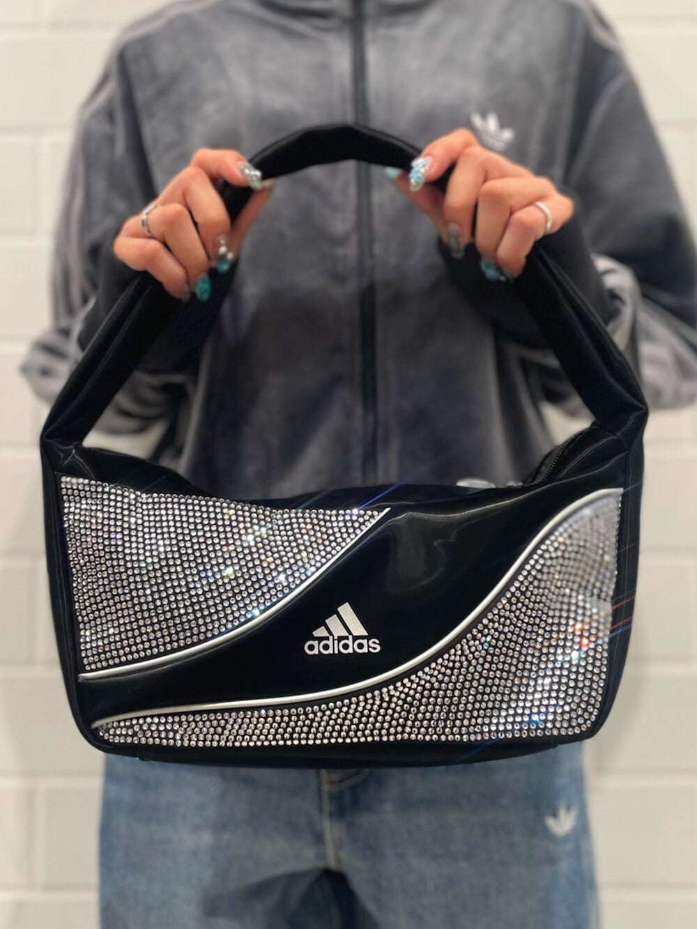 ブラック系のショルダーバッグ、グレー系のスニーカー、ブルー系のパンツを着用したレディースの秋コーディネートの4枚目の写真