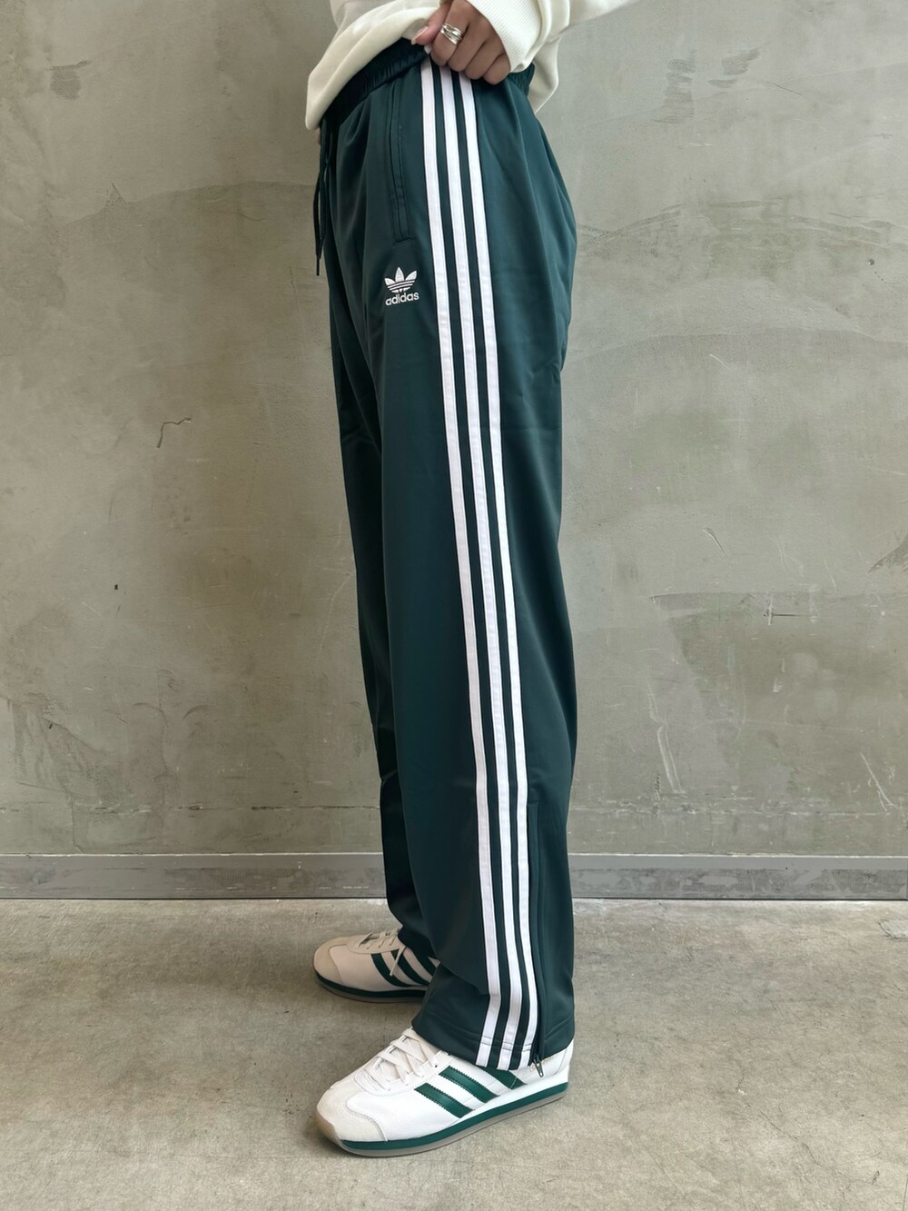 ブラック系のダウンジャケット/コート、ホワイト系のポロシャツ、グリーン系のスウェットパンツを着用したレディースの秋コーディネートの7枚目の写真