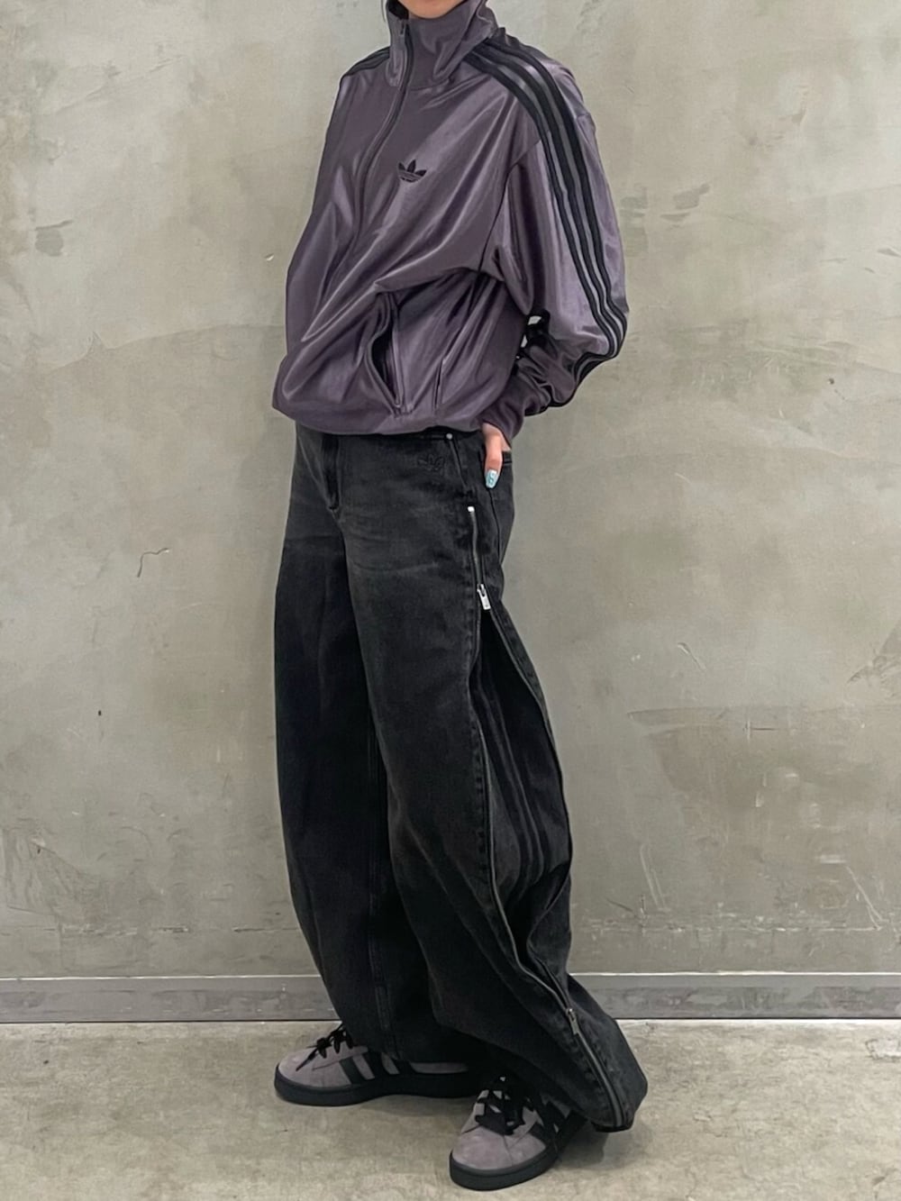 ブラウン系のスニーカー、グレー系のトップス、ブラック系のデニムパンツを着用したレディースの秋コーディネートの2枚目の写真