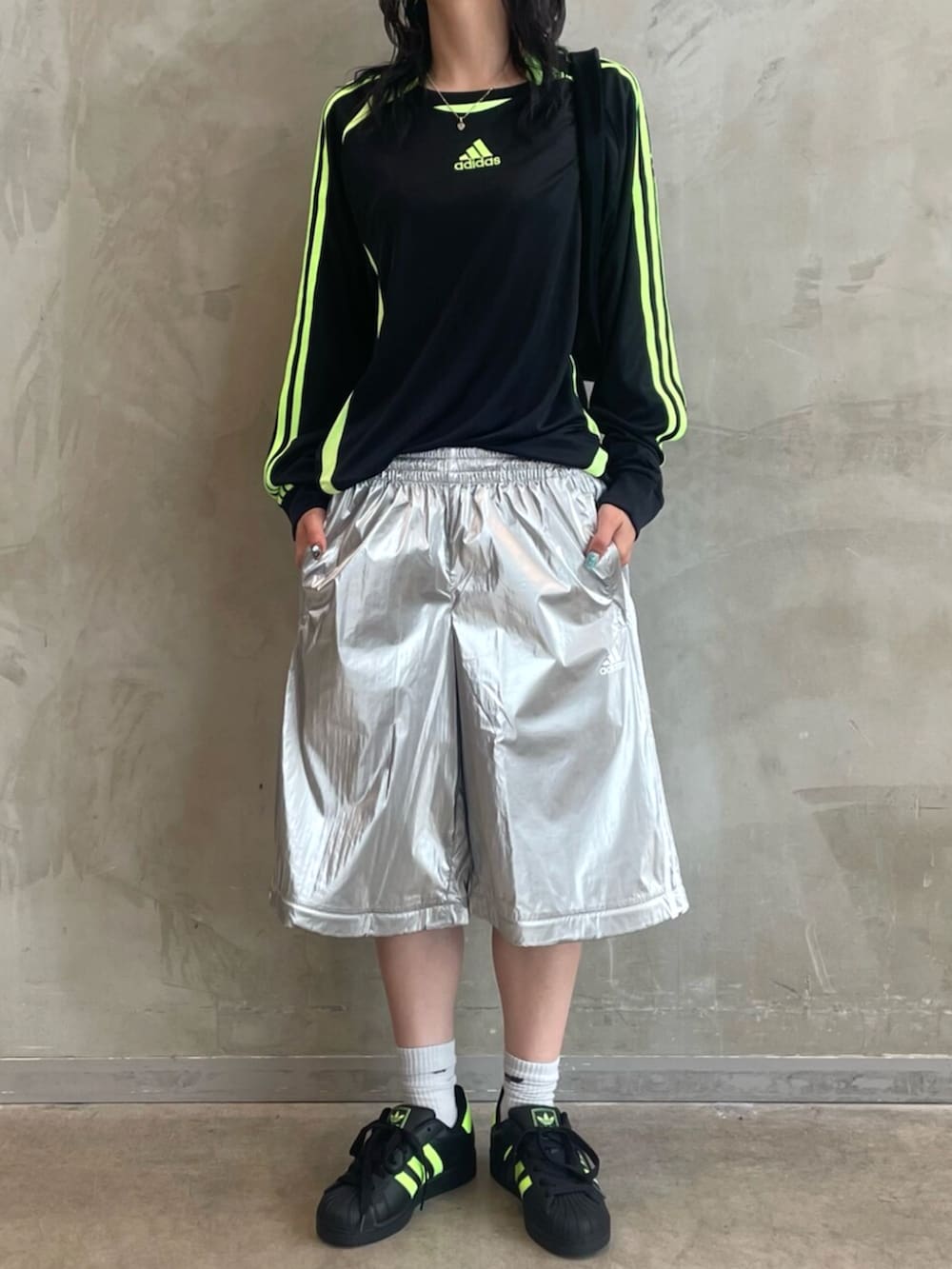 ブラック系のスニーカー、ブラック系のショルダーバッグ、シルバー系のスウェットパンツを着用したレディースの秋コーディネートの2枚目の写真