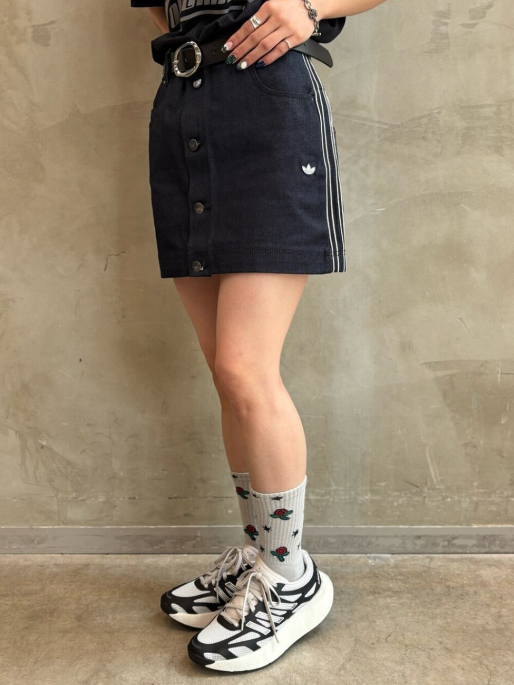シルバー系のショルダーバッグ、ブラック系のスニーカー、ブラック系のトップスを着用したレディースの夏コーディネートの7枚目の写真