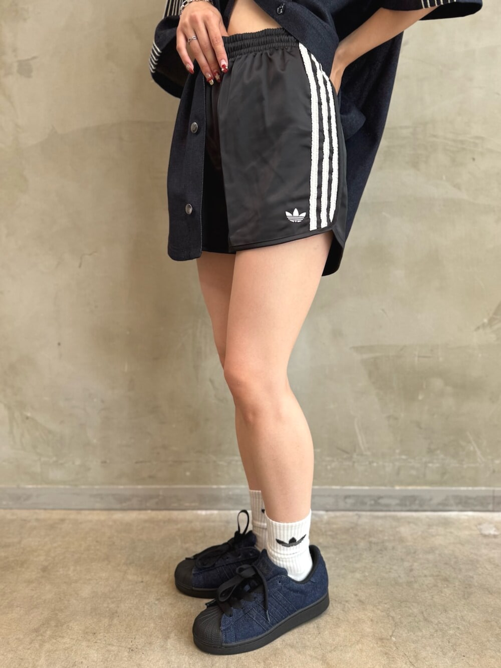 ブルー系のシャツ/ブラウス、ブラック系のパンツ、ブルー系のスニーカーを着用したレディースの夏コーディネートの5枚目の写真