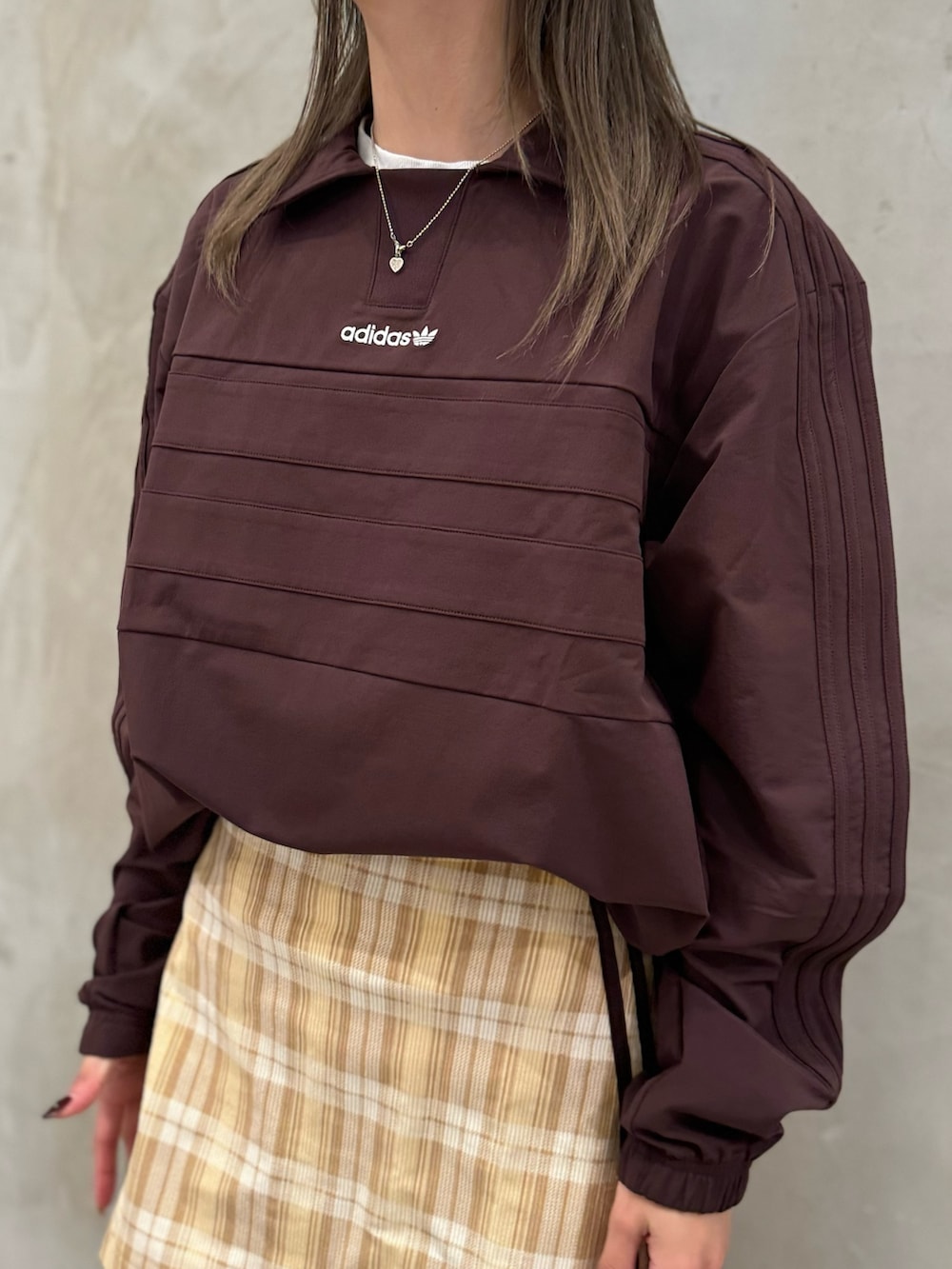 ブラウン系のTシャツ/カットソー、ベージュ系のスカート、ブラック系のショルダーバッグを着用したレディースの秋コーディネートの4枚目の写真