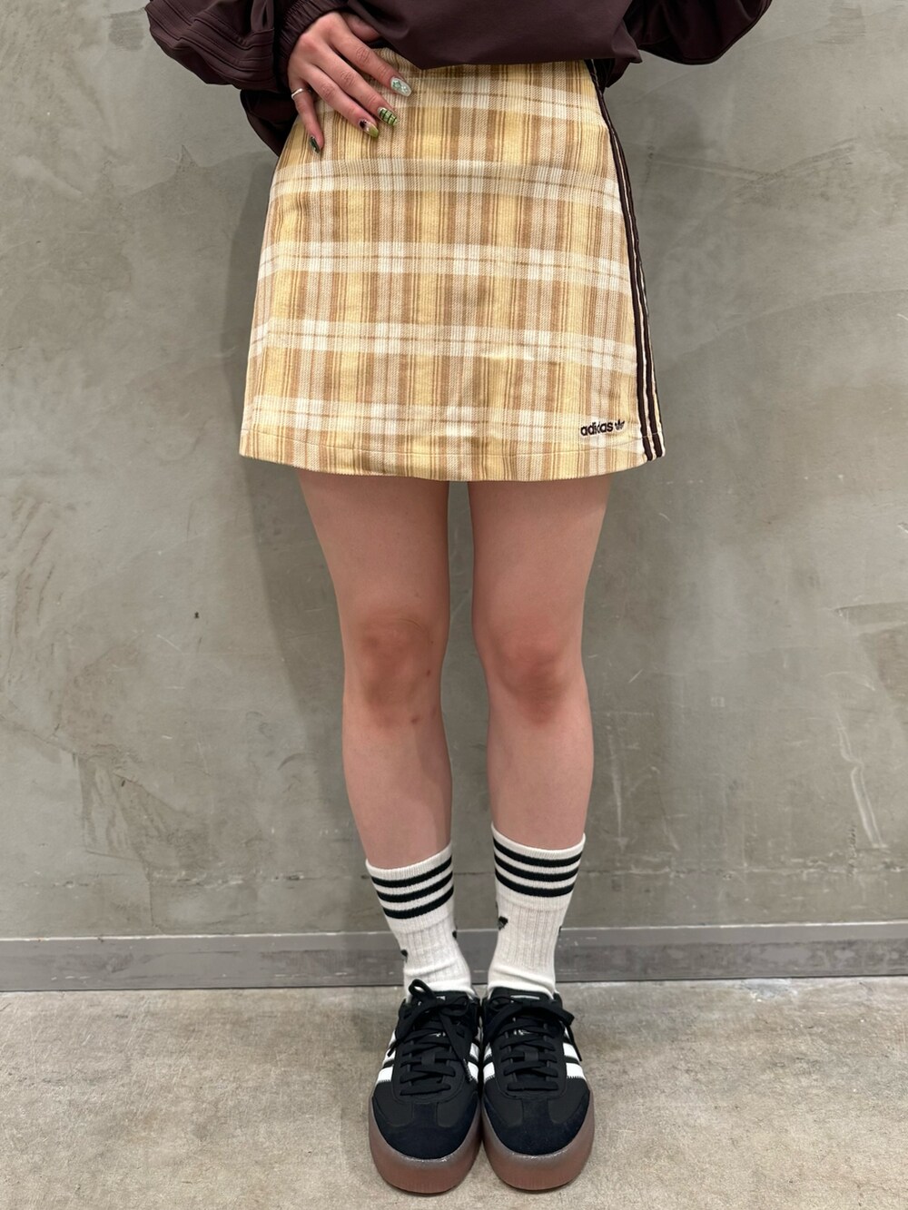 ブラウン系のTシャツ/カットソー、ベージュ系のスカート、ブラック系のショルダーバッグを着用したレディースの秋コーディネートの7枚目の写真