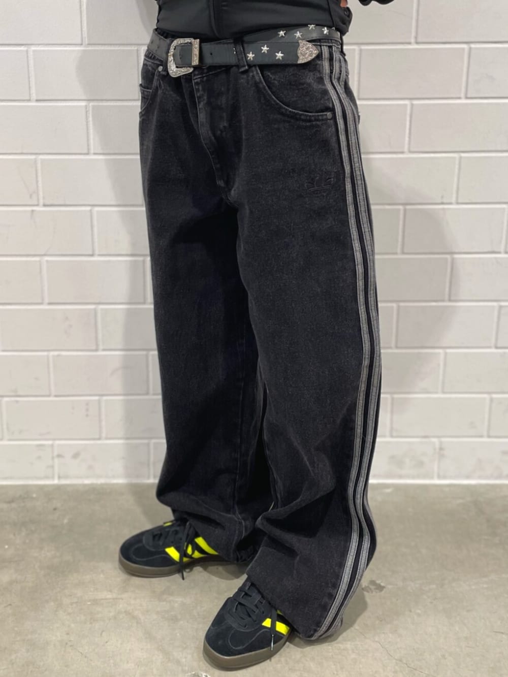 ブラック系のデニムパンツ、ブラック系のスニーカー、ブラック系のジャージを着用したレディースの冬コーディネートの5枚目の写真