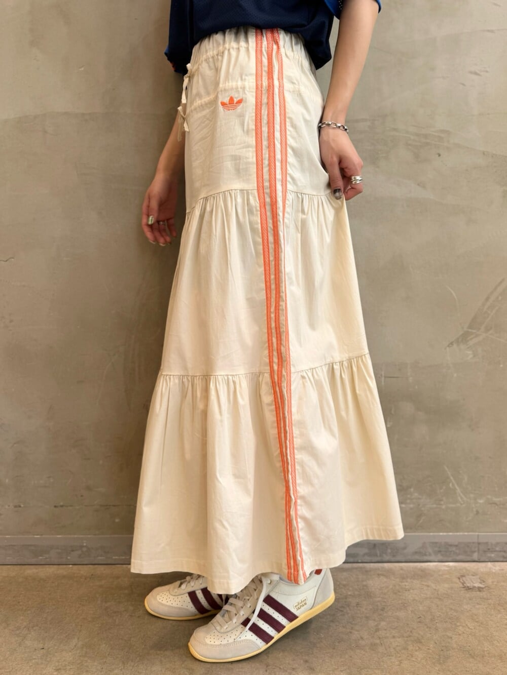 ブルー系のTシャツ/カットソー、ホワイト系のスカート、ホワイト系のスニーカーを着用したレディースの春コーディネートの5枚目の写真