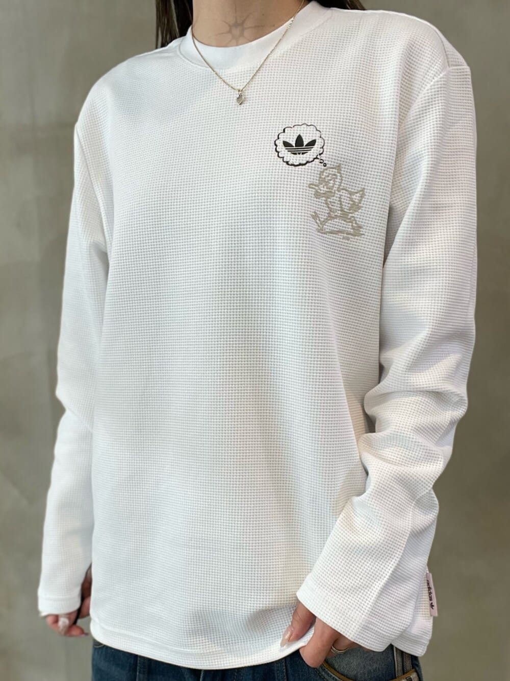 ホワイト系のTシャツ/カットソー、ブラック系のスニーカー、イエロー系のレッグウェアを着用したレディースの冬コーディネートの3枚目の写真