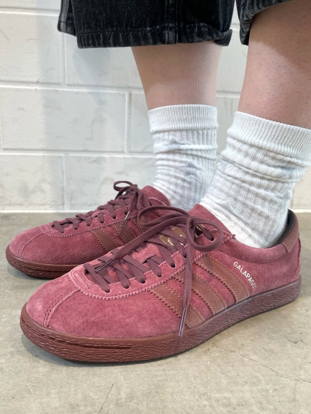 ブルー系のトップス、ブラック系のデニムパンツ、レッド系のシューズを着用したレディースの春コーディネートの6枚目の写真