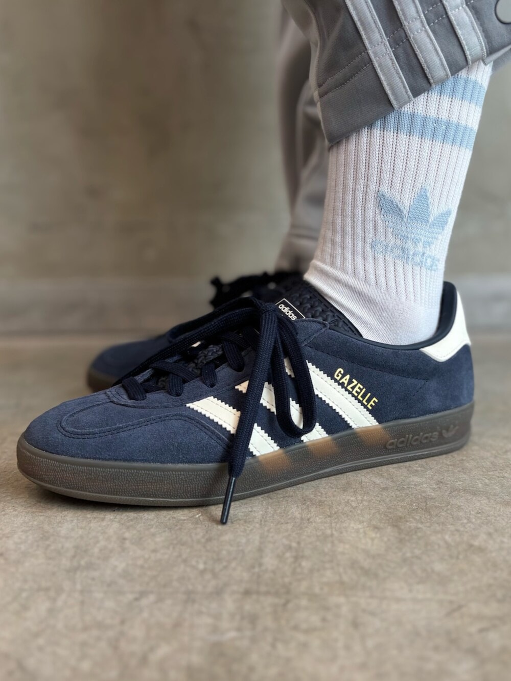 ブルー系のスニーカー、グレー系のパンツ、ホワイト系のバッグを着用したレディースの春コーディネートの8枚目の写真