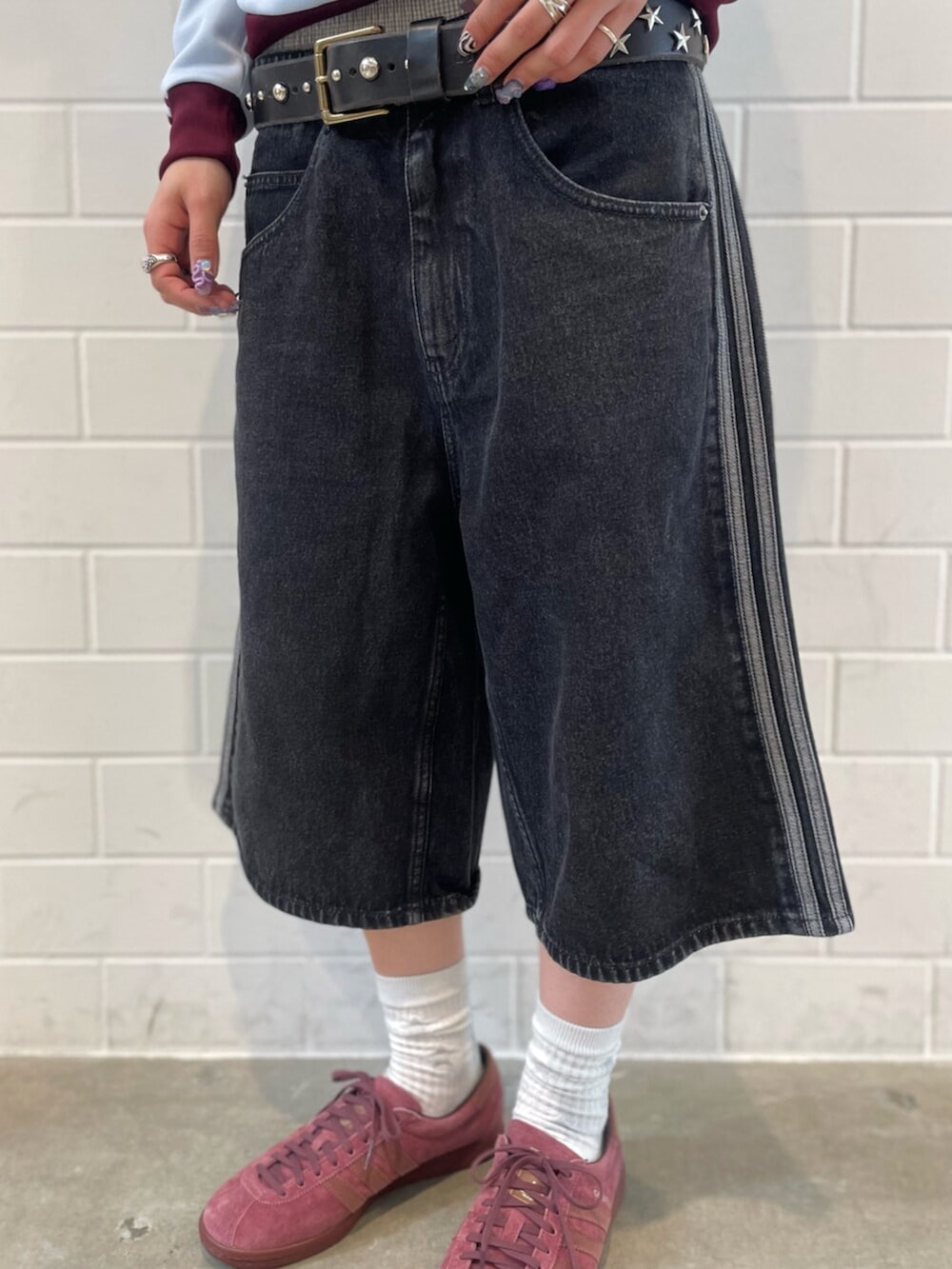 ブルー系のトップス、ブラック系のデニムパンツ、レッド系のシューズを着用したレディースの春コーディネートの5枚目の写真