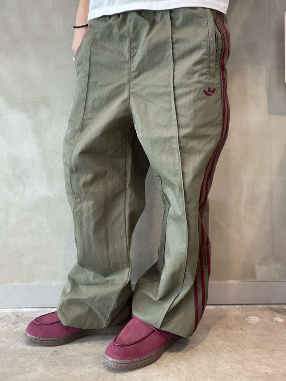 ブラック系のショルダーバッグ、レッド系のスニーカー、グリーン系のその他パンツを着用したレディースの春コーディネートの5枚目の写真