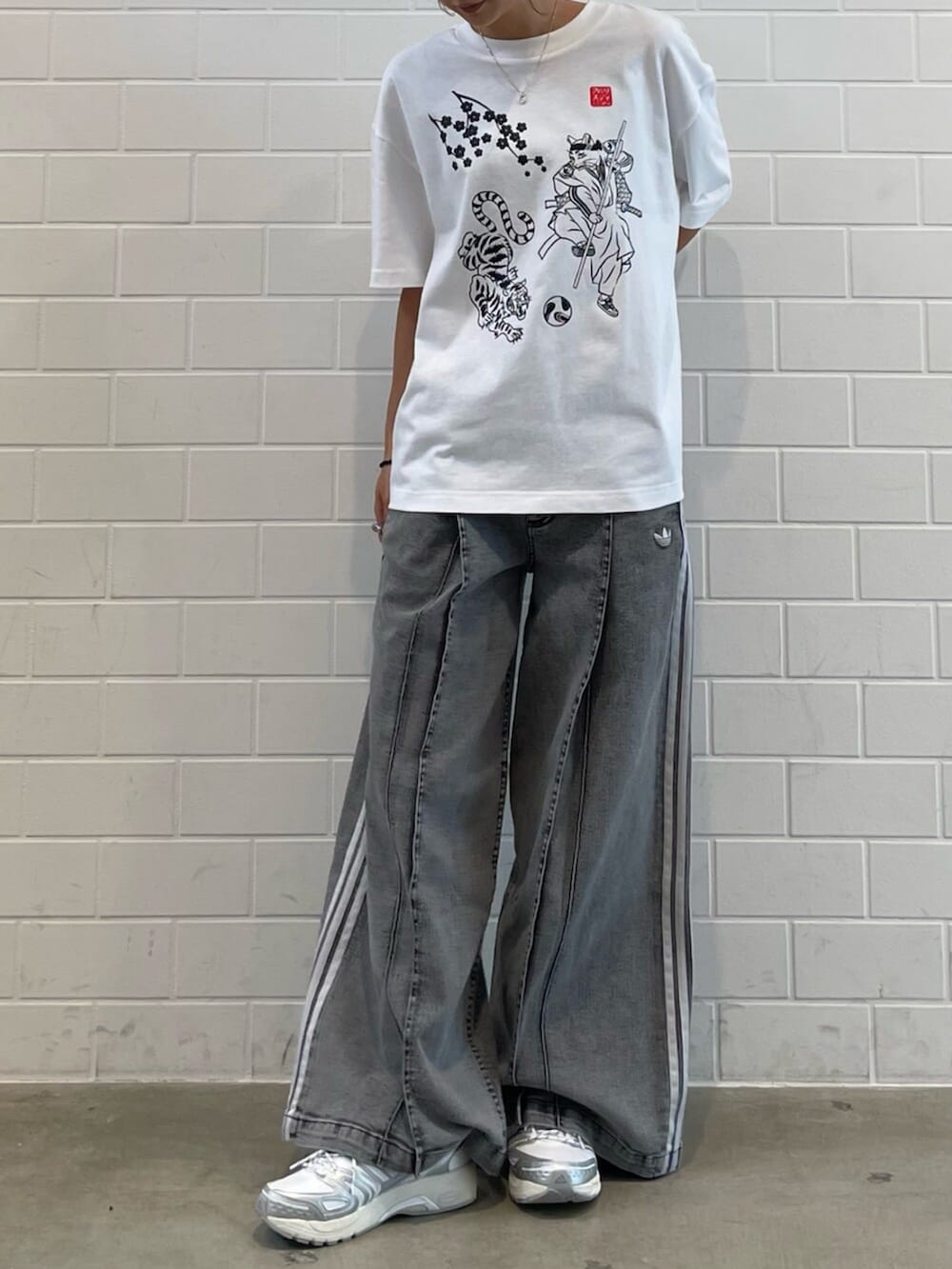 ホワイト系のシューズ、ホワイト系のトップス、グレー系のその他パンツを着用したレディースの夏コーディネートの2枚目の写真