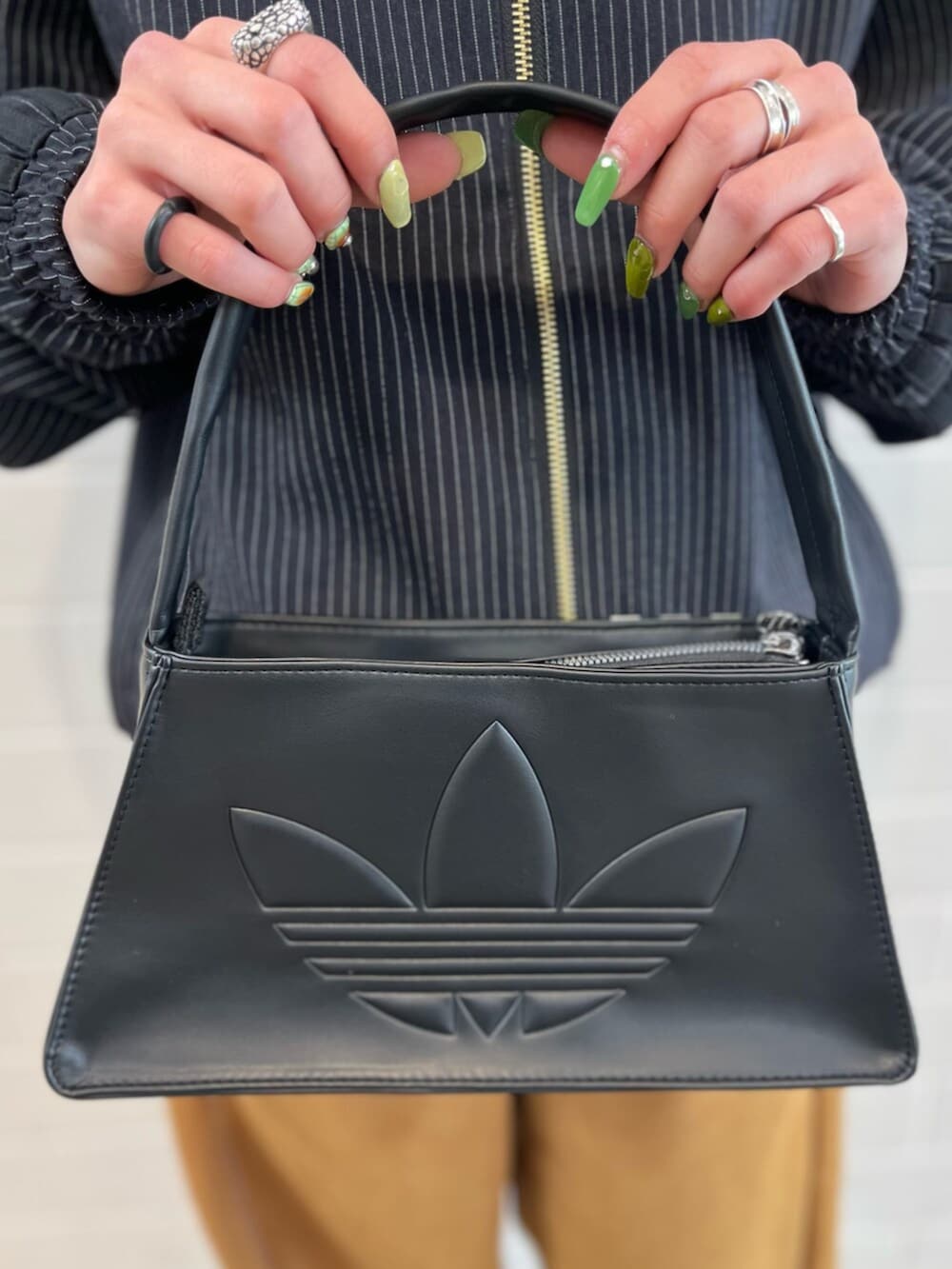 ブラック系のショルダーバッグ、ブラック系のジャージ、ブラック系のスニーカーを着用したレディースの冬コーディネートの4枚目の写真