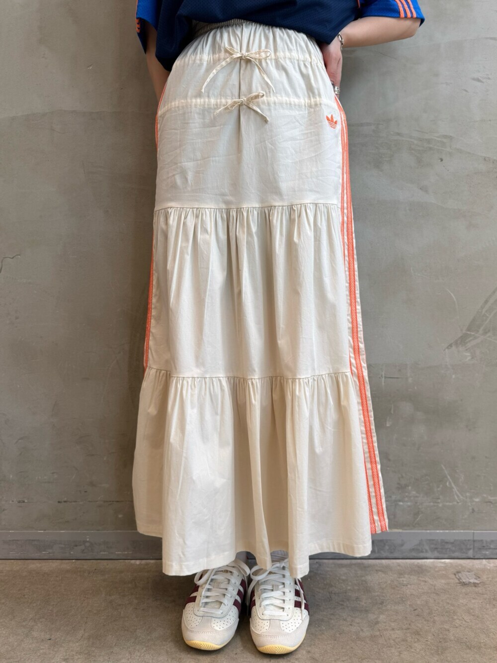 ブルー系のTシャツ/カットソー、ホワイト系のスカート、ホワイト系のスニーカーを着用したレディースの春コーディネートの4枚目の写真