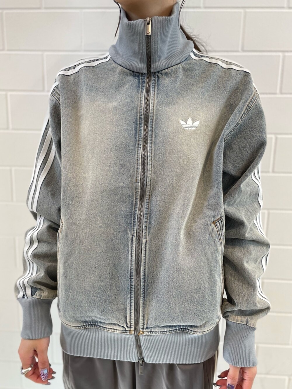 シルバー系のスニーカー、ブルー系のデニムジャケット、グレー系のその他パンツを着用したレディースの春コーディネートの4枚目の写真